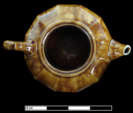 Federal Reserve Site - Panel molded teapot, Rockingham glaze on buff-bodied earthenware, shows side and top view.